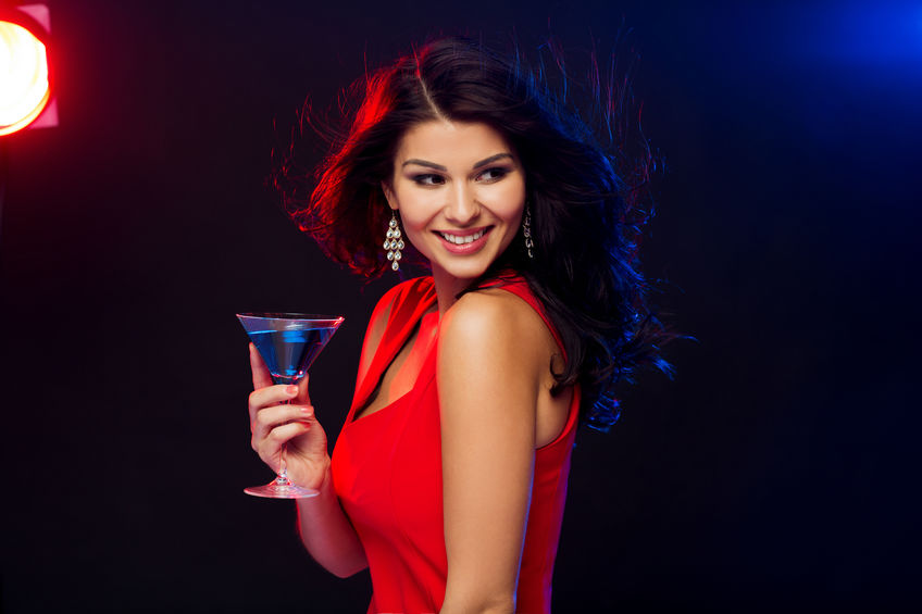 people, holidays, party, alcohol and leisure concept - beautiful sexy woman in red dress with cocktail glass at night club
